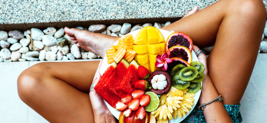 Girl,Relaxing,And,Eating,Fruit,Plate,By,The,Hotel,Pool.